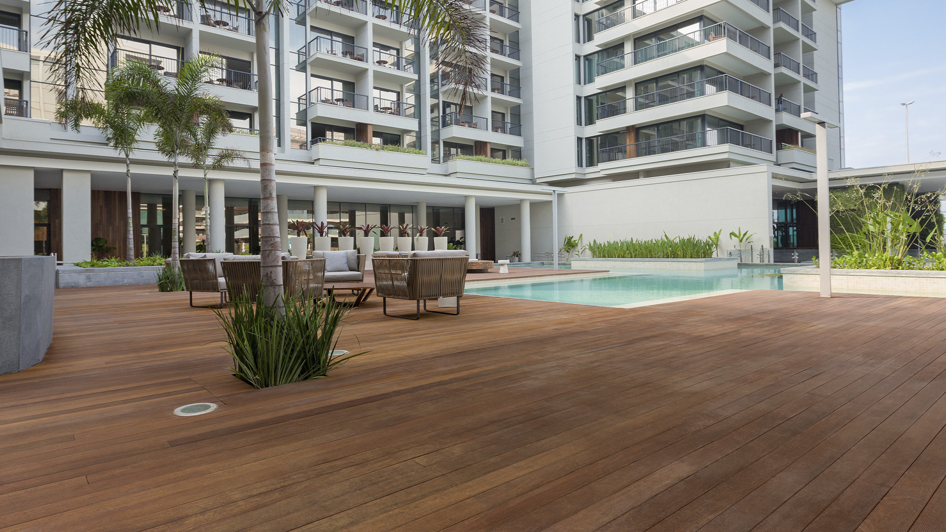 Deck de madeira em área de piscina de condomínio