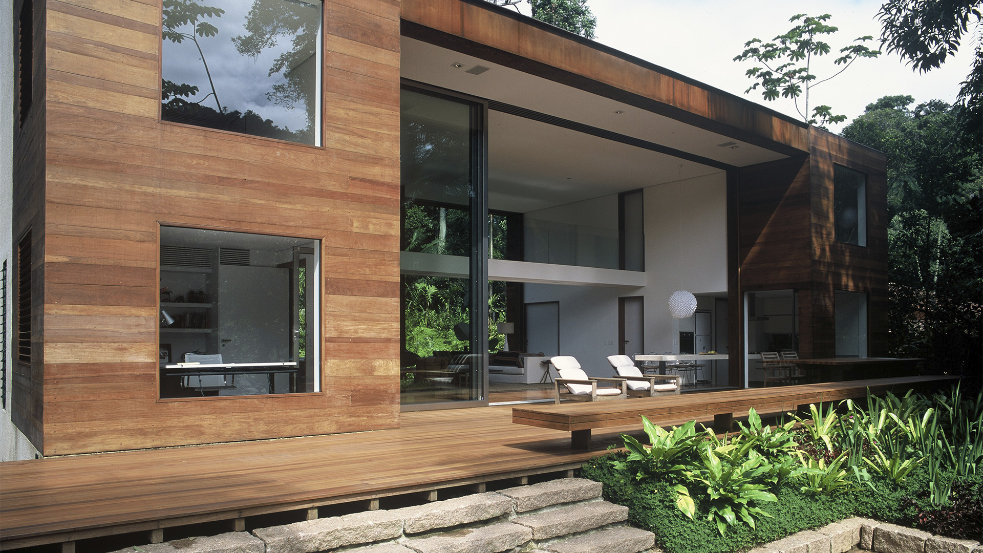 Fachada residencial com revestimento de madeira e deck integrado